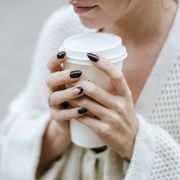 close up of womans hands with take away drink