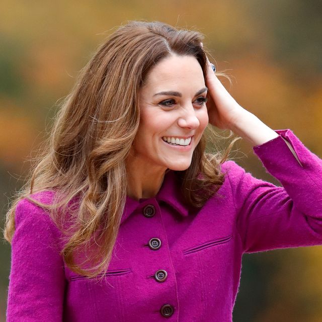 kate middleton smiling while holding her head