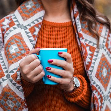 woman in autumn colors holding coffee mug