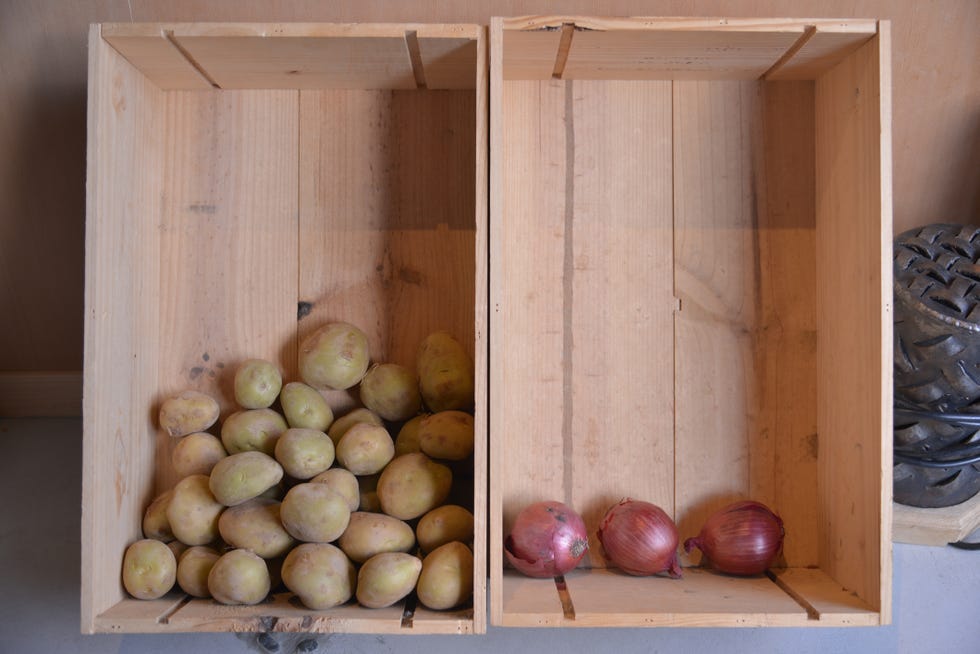 potatoes and onions in two separate wooden boxes