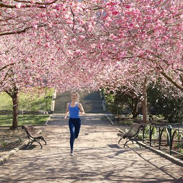 woman running under blossoming trees