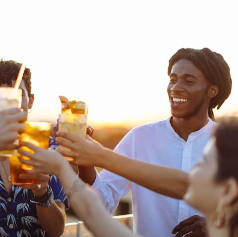 happy multiethnic friends toasting drinks