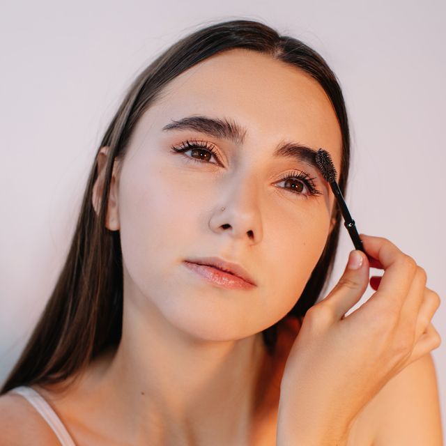 woman brushing her eyebrows