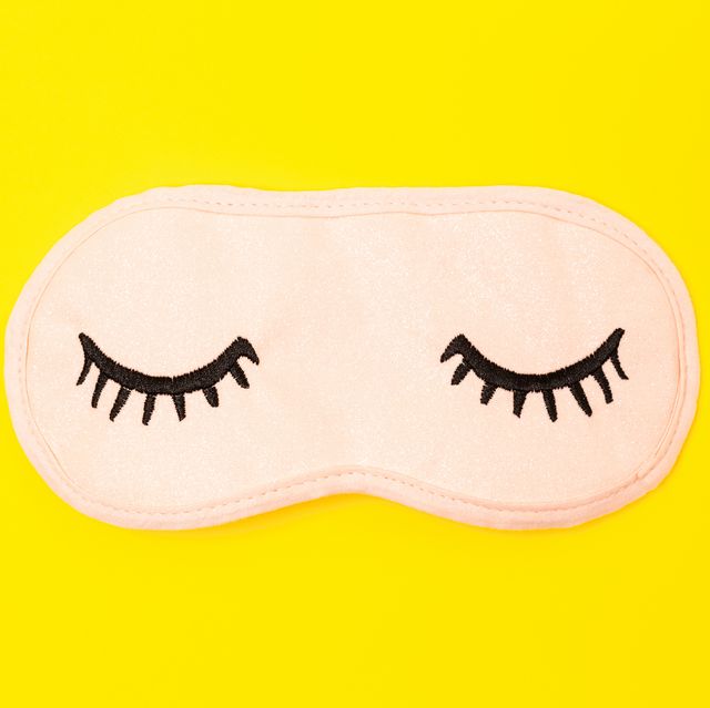 Directly Above Shot Of Eye Mask Over Yellow Background