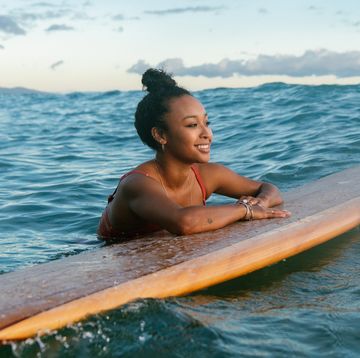 young woman resting on her surfboard waiting for a wave hawaii 2019