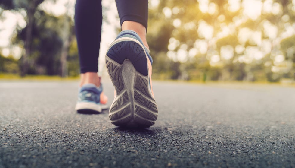 woman feet running on road closeup on shoe young fitness women runner legs ready for run on the road sports healthy lifestyle concept