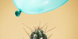 a balloon flying dangerously close to a cactus