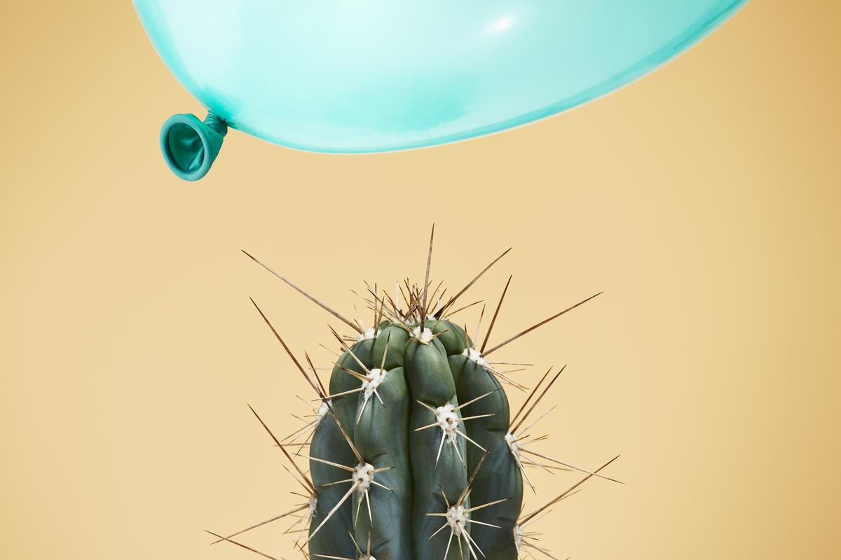 a balloon flying dangerously close to a cactus