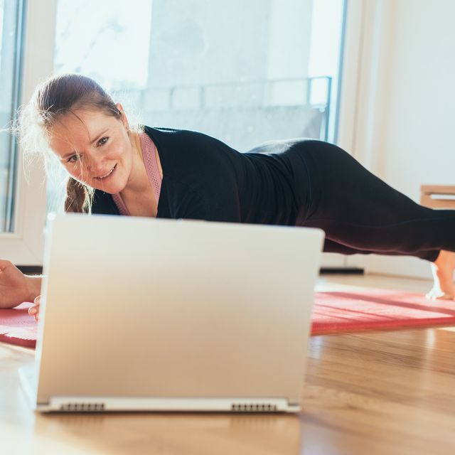 Woman doing sport in front of laptop.