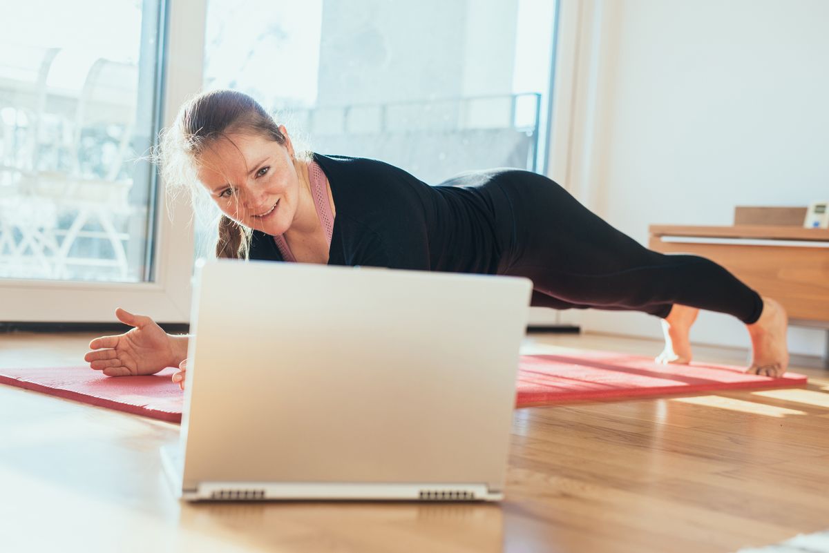 Woman doing sport in front of laptop.