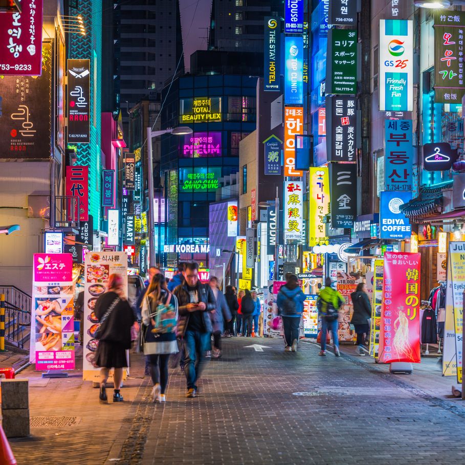 crowds of shoppers along the pedestrianised streets of myeong dong overlooked by the neon lights of stores in the heart of seoul