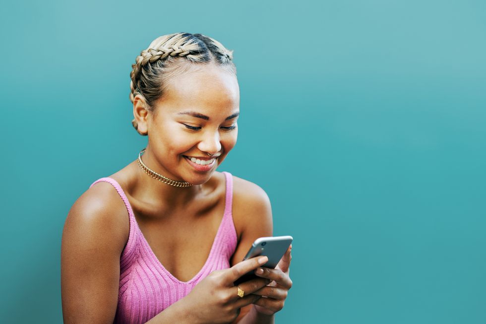 a woman smiling and looking at her phone