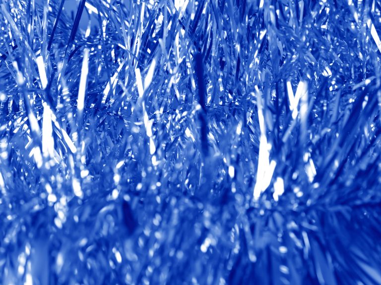 blue tinsel background with selective focus phantom blue tinsel christmas decoration, new year abstract background with shiny glittering tinsels holiday backdrop