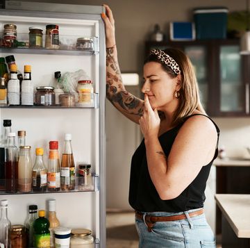 shot of a young woman searching inside a refrigerator at home
