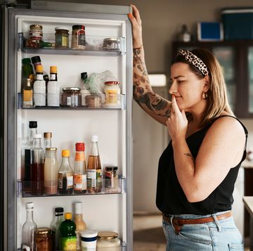 shot of a young woman searching inside a refrigerator at home
