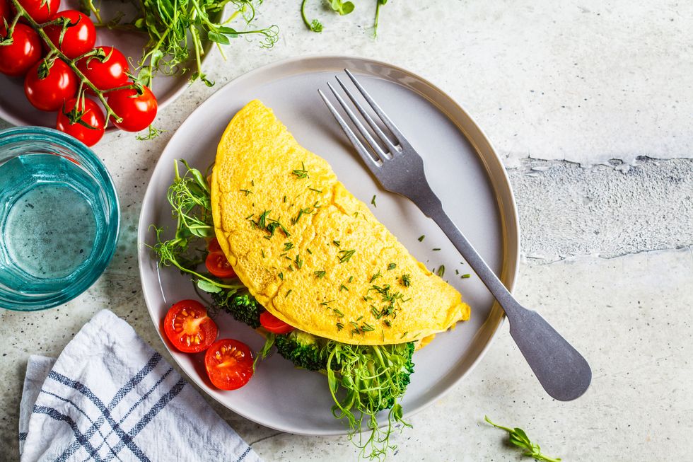 best breakfasts for weight loss vegan chickpea omelet with broccoli, tomatoes and seedlings on a gray plate healthy vegan food concept