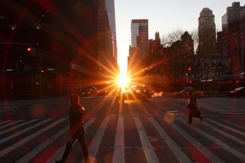 new york, ny   january 22 people walk along 6th avenue as the sun rises above 42nd street  on january 22 2020 in new york city photo by gary hershorngetty images