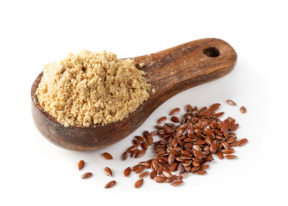 linseed flour in a wooden spoon isolated on a white background
