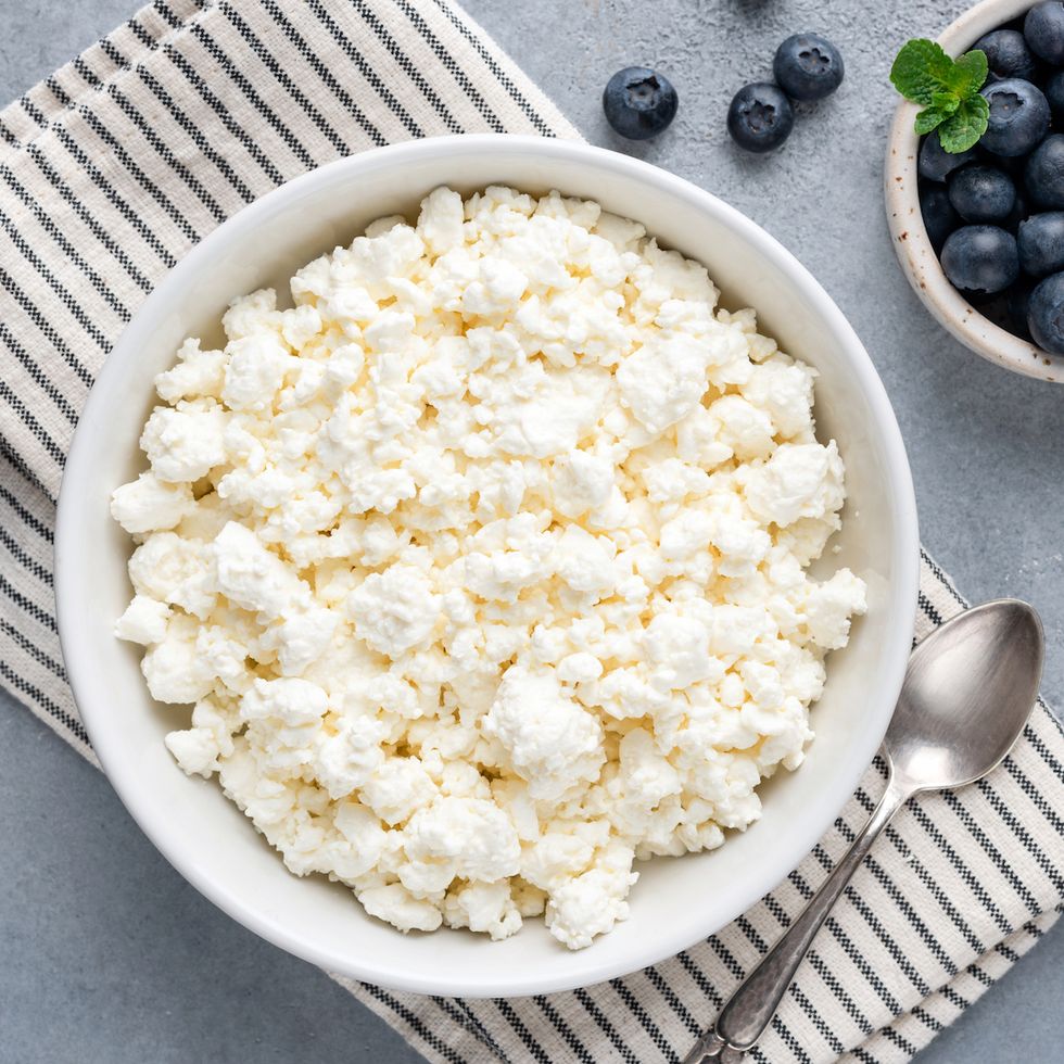 tvorog, cottage cheese or curd cheese in bowl, table top view healthy fermented dairy product rich in calcium and protein farmer's cheese