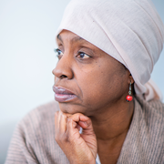 black woman looking off while wearing head scarf