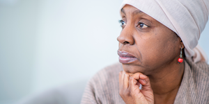 black woman looking off while wearing head scarf