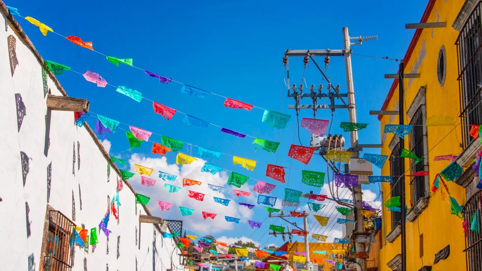 multicolored flags made of papel picadoadorning a street in san miguel de allende, guanajuato, mexico