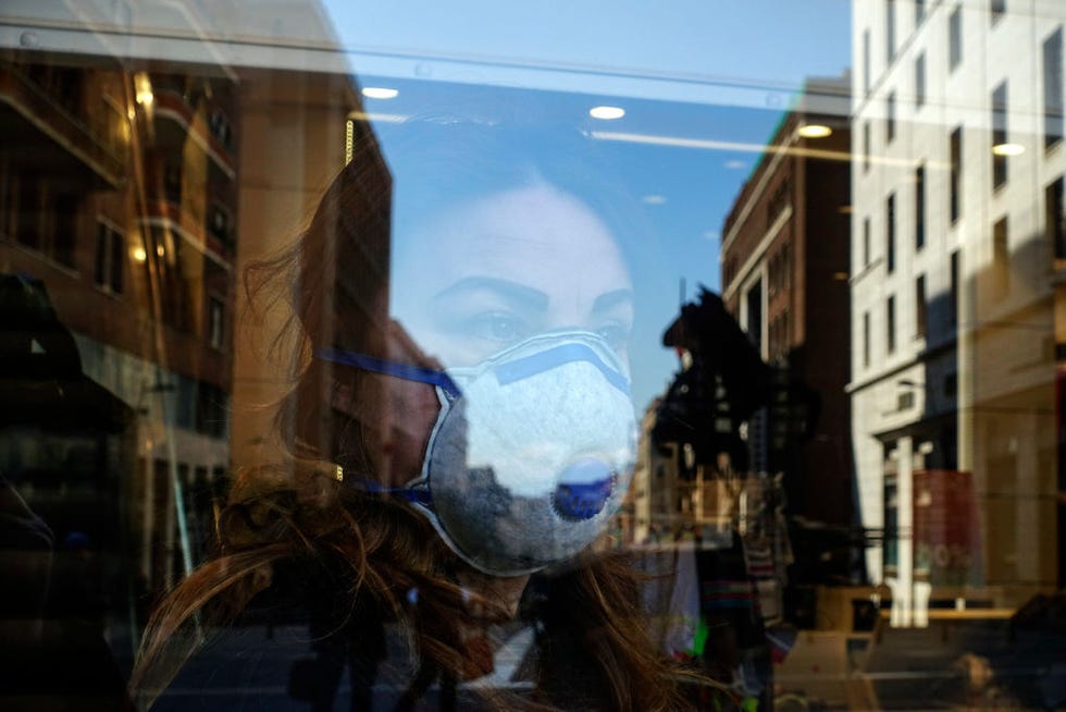 A woman while looking out of a shop, wears an antivirus