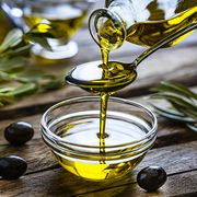 healthy cooking oil, pouring extra virgin olive oil from a spoon to a glass