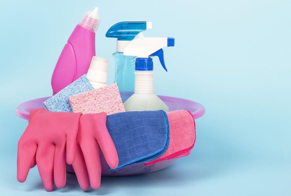 cleaning products, gloves and rags in the basin, a blue background