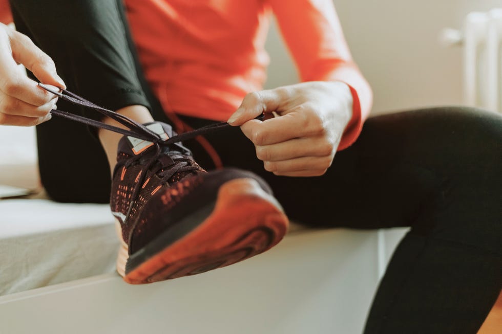 woman tying shoelaces on sneakers and getting ready for morning fitness healthy lifestyle concept