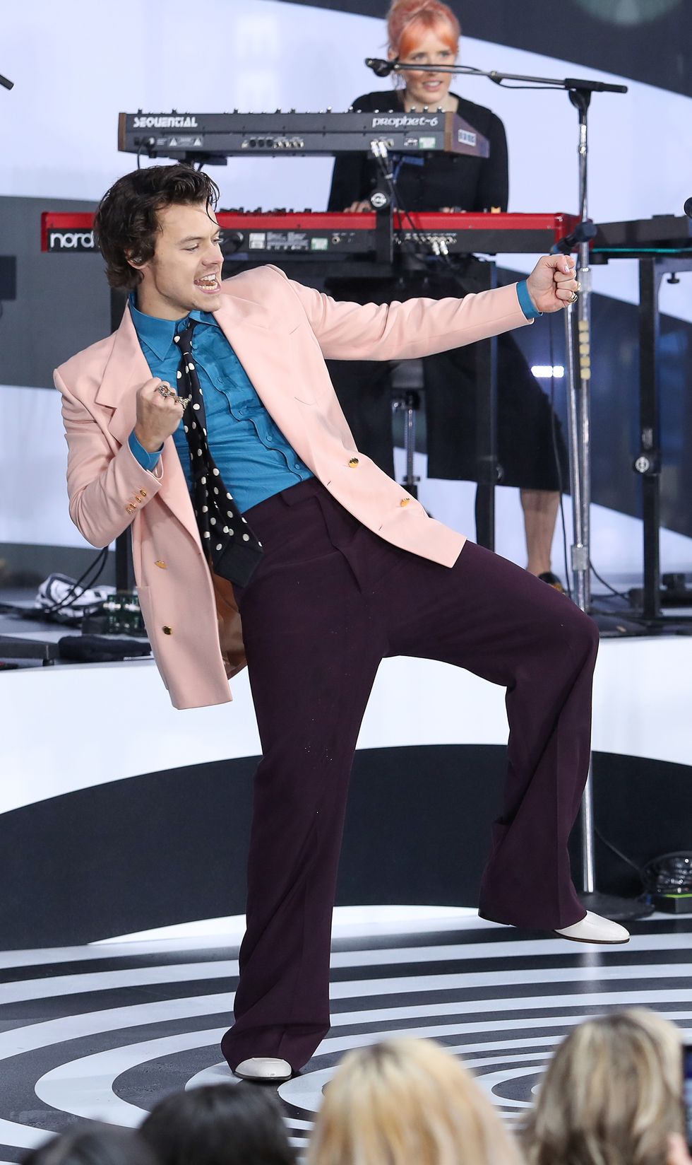 harry styles wearing a pink blazer, purple trousers matched with a blue shirt