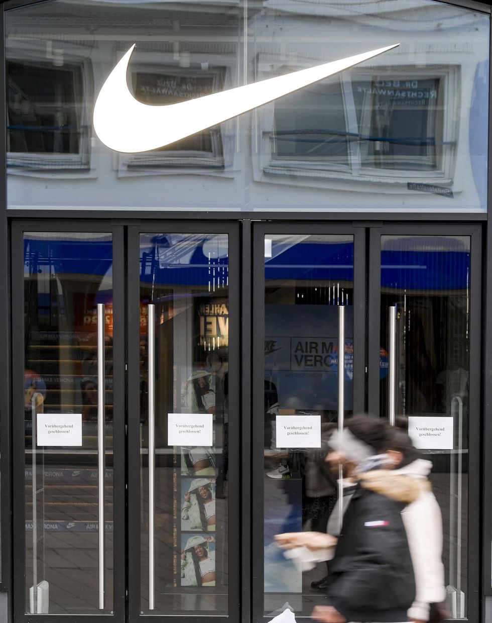 01 april 2020, hamburg passers by walk in front of the closed entrance of a department store of the sports goods manufacturer nike in downtown hamburg photo axel heimkendpa photo by axel heimkenpicture alliance via getty images