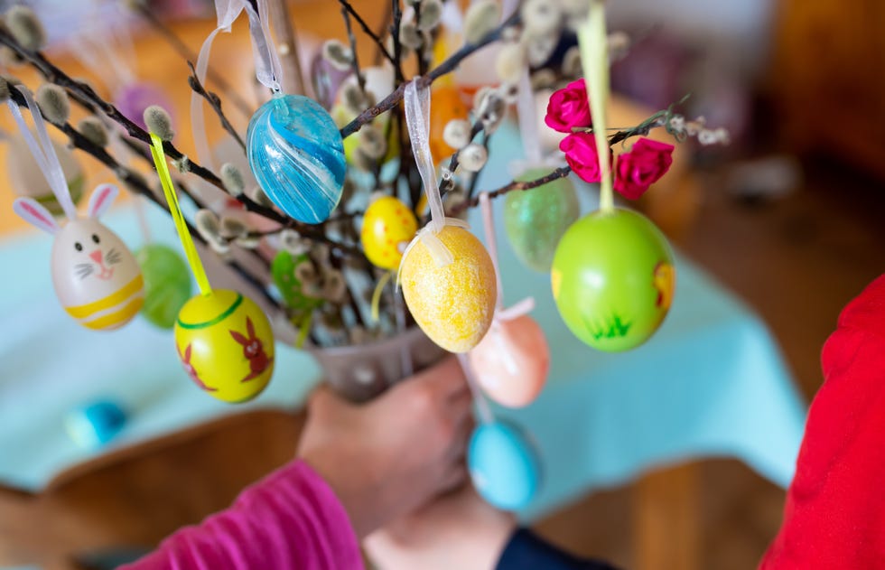 03 april 2020, bavaria, munich two children hold a palm bush with painted easter eggs in their hands church services are cancelled, easter fires are postponed in many places, families cannot meet and yet with creativity and digital technology, easter has a chance photo sven hoppedpa photo by sven hoppepicture alliance via getty images