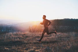 side view of man running in the forest