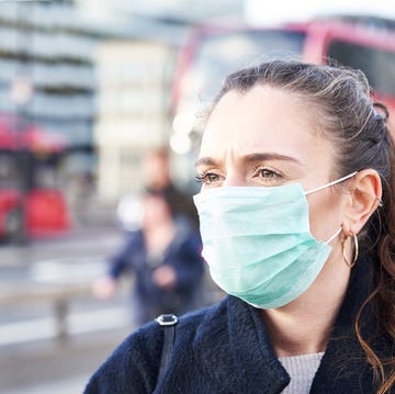 Young woman wearing face mask while walking in the streets of London Young woman wearing face mask while walking in the streets of London