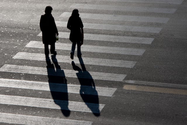 silhouette couple walking on street with shadow behind