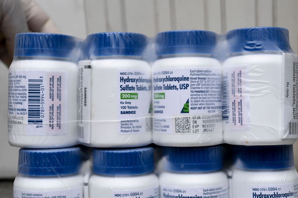 a salvadoran health ministry worker shows a package of bottles of hydroxychloroquine pills to be distributed in hospitals in san salvador on april 21, 2020, amid the covid 19 coronavirus outbreak photo by yuri cortez  afp photo by yuri cortezafp via getty images