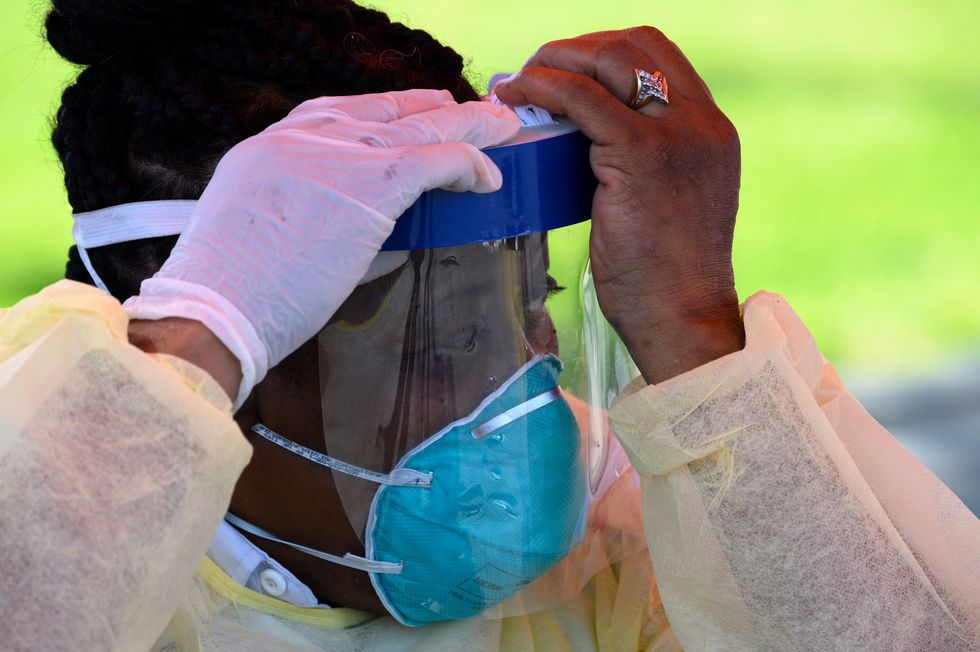 a testing site staff member adjusts her personal protective equipment ppe at a mobile covid 19 testing station in a public school parking area in compton, california, just south of los angeles, on april 28, 2020   st johns well child and family center is providing covid 19 testing sites in african american and latino communities which have been neglected in terms of testing as compared to wealthier areas of los angeles county photo by robyn beck  afp photo by robyn beckafp via getty images