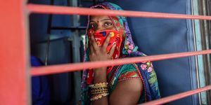 a migrant worker looks out of a compartments window as she sits inside a special train going to agra in uttar pradesh state during a government imposed nationwide lockdown as a preventive measure against the covid 19 coronavirus, at sabarmati railway station on the outskirts of ahmedabad on may 2, 2020 photo by sam panthaky  afp photo by sam panthakyafp via getty images