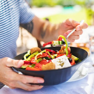 Men eating Greek Salad hombre come ensalada saludable
