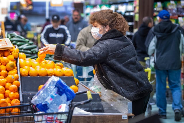 la habra, ca   march 17 a woman wears a mask as she shops for oranges at the northgate market in la habra early on tuesday morning, march 17, 2020, after the store opened at 7 am for seniors over 65 before letting the rest of the public in to shop amid coronavirus buying photo by mark rightmiremedianews grouporange county register via getty images