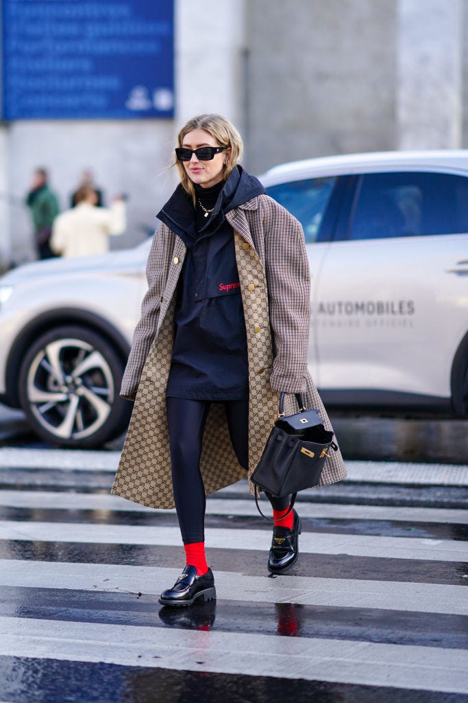 paris, france   february 29 emili sindlev wears sunglasses, a supreme jacket with a hood, a gucci long oversized coat with houndstooth patterns and printed logos on the inner lining, a black leather bag, leggings, red socks, prada logo shoes, a black turtleneck pullover, a necklace, outside rokh, during paris fashion week   womenswear fallwinter 20202021, on february 29, 2020 in paris, france photo by edward berthelotgetty images