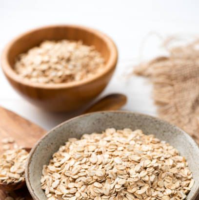 oat flakes, rolled oats in bowl healthy breakfast grains dieting, vegan vegetarian food concept