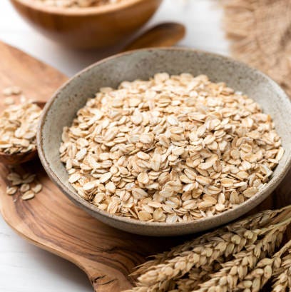 oat flakes, rolled oats in bowl healthy breakfast grains dieting, vegan vegetarian food concept