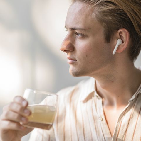 side portrait of a young caucasian male who is drinking a glass of apple juice
