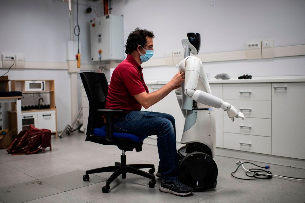 Op het Istituto Italiano di Tecnologia in Genua werkt een ingenieur begin 2020 aan een robot Het instituut ontwerpt robots die reizigers op luchthavens en treinstations de weg kunnen wijzen