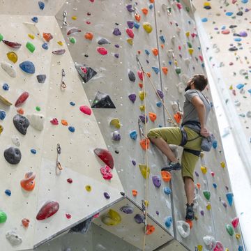 young man indoor rock climbing