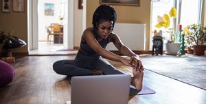close up of a young woman learning yoga online from her laptop