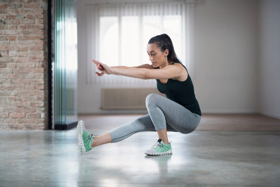 beautiful, young female athlete doing one legged squat