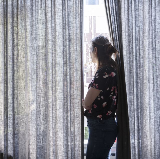 woman looking outside the window during quarantaine